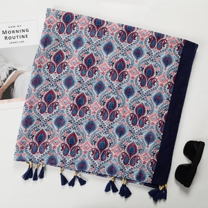 Detail of bohemian cotton linen scarf with blue tassels, wooden beads and paisley patterns