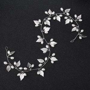 Silver leaf bridal hair vine with white pearls on a textured black background