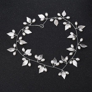 Detail of silver bridal hair vine with metallic leaves and elegant white pearls