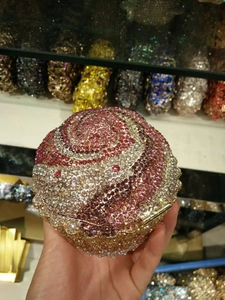 Detailed close-up of pink and silver crystal-encrusted spiral pattern on evening bag