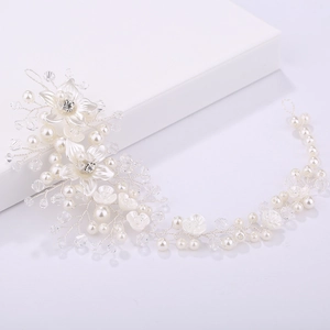 Close-up of handmade bridal headband with white fabric flowers and crystal pearls
