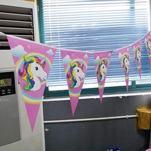 Close-up of pink unicorn and rainbow triangle banner flags for birthday party decor