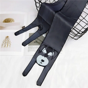 Detail view of black silk skinny scarf with cartoon dog print draped on black metal basket