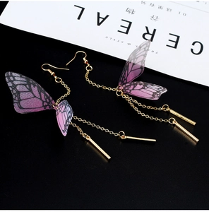 Detail of purple translucent butterfly wing earrings with golden chain tassels