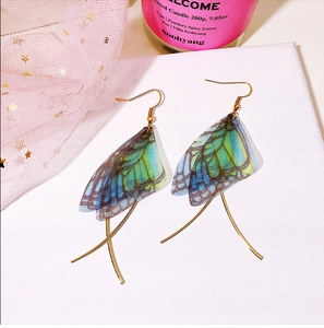 Detail of blue and green gradient butterfly wing earrings with golden tassels