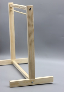 Detailed close-up of natural wood doll clothes rack with smooth grain and metal screws
