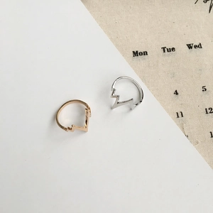 Minimalist heartbeat wave rings in gold and silver finish shown on a decorative background