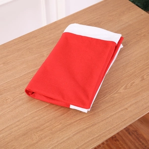 Christmas tablecloth 132x208cm in red and white fabric on a wooden background