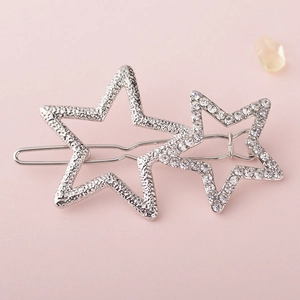 Silver alloy hair clip with hammer texture star and rhinestone star on pink background