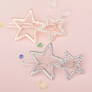 Detail showing two hollow star hair clips in rose gold and silver with rhinestones