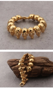 Close-up of golden stainless steel skull bracelet with punk style linked elements