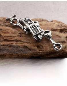 Detailed view of Gothic skull link bracelet in vintage steel on dark wood texture