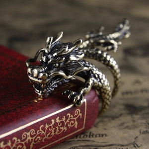 Vintage bronze dragon ring with intricate scales resting on a red antique book