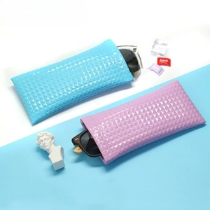 Detail of 3D diamond texture portable faux leather cases for sunglasses in blue and purple