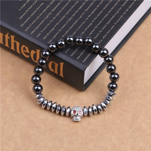 Détail du bracelet à perles avec crâne argenté aux yeux rouges et hématite noire