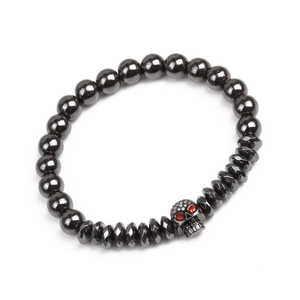 Détail de perles d'hématite et tête de mort en zircon aux yeux rouges sur bracelet punk