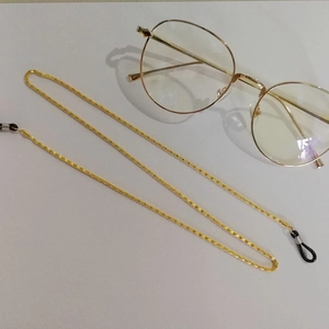 Detail of gold braided metal glasses chain with black anti-slip rubber loops and slider