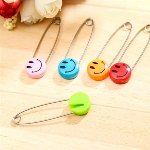 Detail showing five colorful smiley face safety pins for knitting and DIY projects