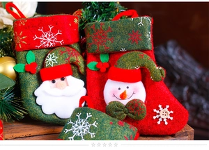 Close-up of felt Christmas stockings with Santa and snowman patterns on wood base