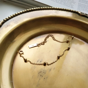 Detail of S925 sterling silver gold beaded bracelet on a vintage brass tray