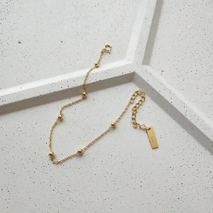 Detail view of gold S925 sterling silver beaded bracelet with adjustable chain link