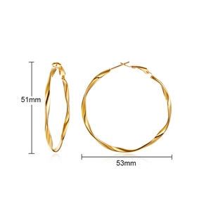 Macro view of gold Mobius hoop earrings showing twisted metal texture and 53mm diameter
