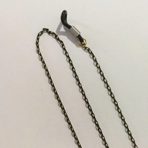 Detailed macro of bronze eyewear chain with black silicone non-slip loops and metal springs