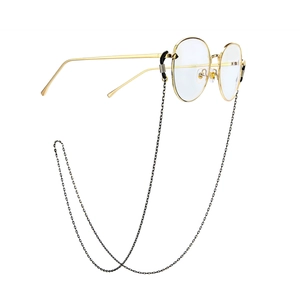 Detail of vintage round gold metal glasses with anti-slip black chain and frame specs