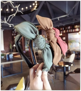 Detailed view of three fabric bow headbands in green, caramel, and pink with vertical textures