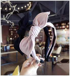Detail of fabric bow headbands in black and pink with pleated wrap design