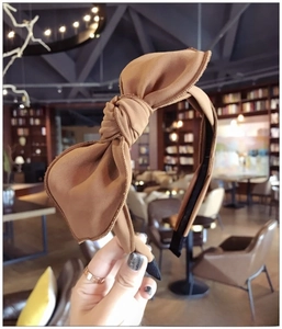 Close-up of a minimalist brown fabric headband featuring a stylish bow knot detail