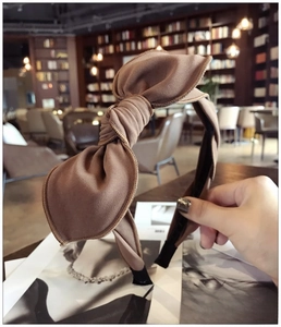 Close-up of brown bow headband showing detailed fabric texture and elegant knot design