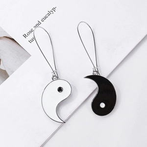Detail shot of Yin Yang Tai Chi earrings with black and white enamel finish on a metal hook