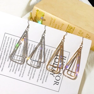 Detailed shot of geometric multi-layer rhinestone earrings in gold and silver finish