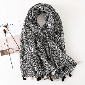 Détail d'une écharpe bohème noir et blanc avec des finitions à franges élégantes