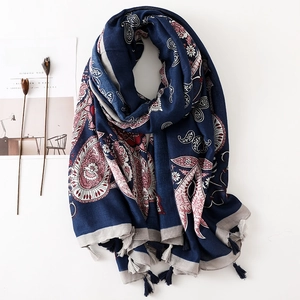 Détail d'un châle en coton bleu marine avec imprimé cachemire et glands tressés élégants