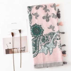 Détails de motifs paisley et glands gris sur un châle en coton et lin fleuri