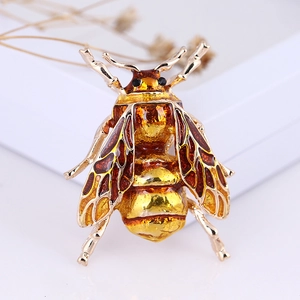 Macro shot of honey bee brooch with golden enamel wings and amber crystal details