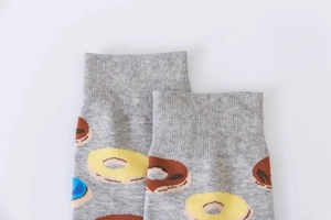 Detailed close-up of grey cotton socks featuring brown and yellow donut patterns and ribbed cuffs