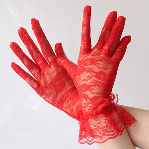 Detail of red floral lace gloves featuring elegant ruffled cuffs and vintage mesh texture