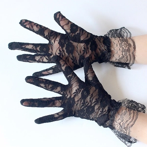Detail of black lace gloves with elegant floral cutouts and ruffled wrist trim