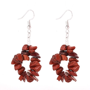 Détail de boucles d'oreilles faites main avec des perles de jaspe rouge naturel