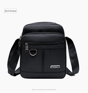 Detailed front view of black oxford messenger bag with dual zippers and brand logo
