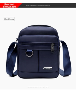 Detail view of water-resistant oxford fabric and metal brand logo on navy crossbody bag