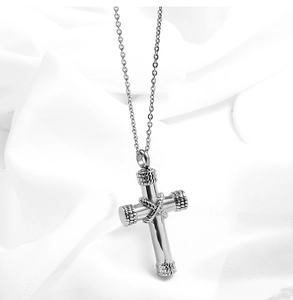 Detailed macro view of silver stainless steel cross pendant with woven texture details