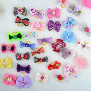 Détail de divers nœuds papillon colorés pour animaux avec perles sur fausse fourrure blanche