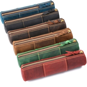 Detailed stack of vintage leather pen cases in various colors with handmade stitching