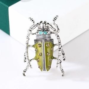 Detail of vintage enamel beetle brooch with champagne rhinestones on a white gift box