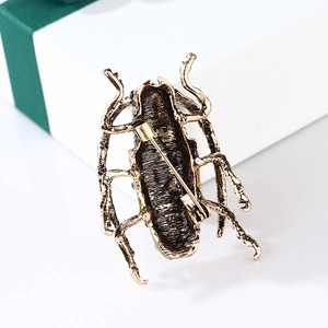 Macro shot of vintage bronze grasshopper brooch with pin back detail and gift box packaging