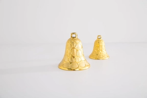 Macro shot of gold decorative bells with unique circular embossed texture and metallic finish